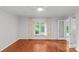Bright bedroom with hardwood floors, large window with patterned curtains, and neutral paint at 5306 Sandtrap Ln, Charlotte, NC 28226