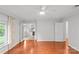 Bright bedroom featuring hardwood floors, a ceiling fan, and access to a separate office space at 5306 Sandtrap Ln, Charlotte, NC 28226