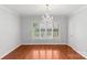 Light-filled dining room featuring hardwood floors, a chandelier, and plantation shutters at 5306 Sandtrap Ln, Charlotte, NC 28226