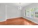 Bright dining room with hardwood floors, a crystal chandelier, and shuttered windows at 5306 Sandtrap Ln, Charlotte, NC 28226