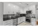 Well-equipped kitchen with stainless steel appliances, black counters, and white cabinetry at 5306 Sandtrap Ln, Charlotte, NC 28226