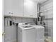 Functional laundry room with washer, dryer, shelving, and storage cabinets at 5306 Sandtrap Ln, Charlotte, NC 28226