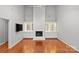 Spacious living room with hardwood floors, a fireplace, and custom built-in cabinets at 5306 Sandtrap Ln, Charlotte, NC 28226