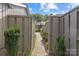 Charming side yard pathway with brick pavers nestled between privacy fencing and manicured greenery at 5306 Sandtrap Ln, Charlotte, NC 28226