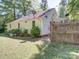 A backyard view displaying the exterior of the house, the lawn, and part of the fence at 610 N Pine Ln, Wadesboro, NC 28170