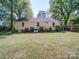 A view of the backyard showing the rear of the home and the surrounding lawn at 610 N Pine Ln, Wadesboro, NC 28170