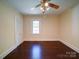 Spacious bedroom featuring a ceiling fan, a closet, and hardwood floors at 610 N Pine Ln, Wadesboro, NC 28170