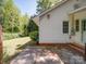 Exterior shot of the rear corner of the house with white siding and brick foundation at 610 N Pine Ln, Wadesboro, NC 28170