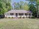 Charming single-story home featuring white siding, black shutters, and manicured landscaping at 610 N Pine Ln, Wadesboro, NC 28170
