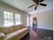 Sun-filled living room with hardwood floors, a sofa, and a doorway leading to the updated kitchen at 610 N Pine Ln, Wadesboro, NC 28170