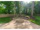 Inviting backyard featuring brick patio, stone fire pit, manicured lawn and flowering plants at 6101 Park Hill Rd, Charlotte, NC 28277