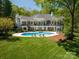 Breathtaking backyard with a luxurious pool, hot tub, and sprawling lawn, ideal for recreation at 7912 Baltusrol Ln, Charlotte, NC 28210