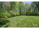 Expansive backyard with lush lawn and mature trees offers privacy and space for outdoor activities at 7912 Baltusrol Ln, Charlotte, NC 28210
