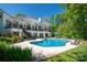 Gorgeous backyard with a pool, manicured lawn, and a stylish white home with balconies at 7912 Baltusrol Ln, Charlotte, NC 28210