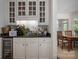 Elegant bar area with a wine refrigerator, sink, and display cabinets, perfect for entertaining guests at 7912 Baltusrol Ln, Charlotte, NC 28210