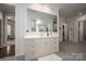 Stylish bathroom with a large mirror, marble countertop, vanity with drawers, and light gray floor tiles at 7912 Baltusrol Ln, Charlotte, NC 28210