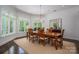 Elegant dining room with a chandelier, large windows, and a wooden table with seating for six at 7912 Baltusrol Ln, Charlotte, NC 28210