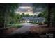 Stately home features a circular driveway and mature landscaping, creating a welcoming and private setting at 7912 Baltusrol Ln, Charlotte, NC 28210