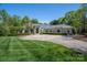 Stately home with circular driveway, lush lawn, and manicured landscaping creating a grand entrance at 7912 Baltusrol Ln, Charlotte, NC 28210
