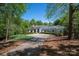 Stately home features a circular driveway and mature landscaping, creating a welcoming and private setting at 7912 Baltusrol Ln, Charlotte, NC 28210