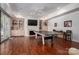 Large game room with fireplace, built-ins, ceiling fan, pool table, and hardwood floors at 7912 Baltusrol Ln, Charlotte, NC 28210