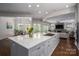 Open concept kitchen with marble island, gas range, and seamless flow into the dining and living areas at 7912 Baltusrol Ln, Charlotte, NC 28210