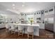 Bright kitchen features a large central island with seating, stainless appliances, and light gray cabinets at 7912 Baltusrol Ln, Charlotte, NC 28210