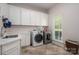 Laundry room features a sink, washer, dryer, window, and white cabinetry at 7912 Baltusrol Ln, Charlotte, NC 28210