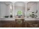 Bright living room features hardwood floors, fireplace, and large windows with views of lush greenery at 7912 Baltusrol Ln, Charlotte, NC 28210