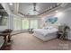 Serene main bedroom with bay windows, tray ceiling, ceiling fan, and ample natural light at 7912 Baltusrol Ln, Charlotte, NC 28210