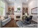 Cozy home office with fireplace, built-in bookshelves, and large window providing ample natural light at 7912 Baltusrol Ln, Charlotte, NC 28210