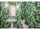 Charming powder room with tropical wallpaper, pedestal sink, and classic fixtures at 7912 Baltusrol Ln, Charlotte, NC 28210