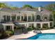 Spacious white home with an elegant deck, hot tub, and pool for outdoor enjoyment and relaxation at 7912 Baltusrol Ln, Charlotte, NC 28210