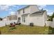An exterior view of home shows a well-maintained lawn with patio furniture and grill for entertaining at 8424 Spirea Ct, Charlotte, NC 28215