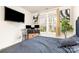 This bedroom shows a mounted TV, bright windows, a side table with computer monitors, and hardwood floors at 8424 Spirea Ct, Charlotte, NC 28215