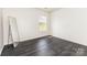 Bright bedroom features hardwood floors, a large window, and neutral paint, ready for personalization at 8424 Spirea Ct, Charlotte, NC 28215