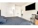 A bedroom with hardwood floors, dark upholstered bed, a floor lamp, and bright white walls at 8424 Spirea Ct, Charlotte, NC 28215