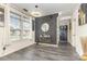 Stylish entryway with patterned accent wall, hardwood floors, modern light fixture and front door at 8424 Spirea Ct, Charlotte, NC 28215