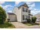 This two-story home with attached garage features neutral siding, black shutters and landscaped front yard at 8424 Spirea Ct, Charlotte, NC 28215