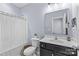 Cozy bathroom featuring a shower/tub, toilet and vanity with a white sink and black cabinet at 8429 Golden Stone Ln, Fort Mill, SC 29707