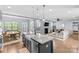 Open-concept kitchen with granite island, farmhouse sink, and views into the adjacent living room at 8429 Golden Stone Ln, Fort Mill, SC 29707