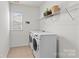 Well-lit laundry room featuring modern washer and dryer units with wire shelving at 8429 Golden Stone Ln, Fort Mill, SC 29707