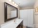 Well-lit bathroom featuring a vanity with a large mirror and a shower with a white curtain at 9029 J M Keynes Dr # 63, Charlotte, NC 28262