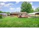 Spacious backyard with a deck, carport, and mature trees, offering a private outdoor retreat at 907 E 9Th Ave, Gastonia, NC 28054