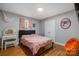 Cozy bedroom features hardwood floors, neutral walls, and a charming vanity with round pink mirror at 907 E 9Th Ave, Gastonia, NC 28054