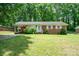 Charming brick home with a well-manicured lawn and inviting front entrance with carport at 907 E 9Th Ave, Gastonia, NC 28054