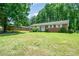 Traditional brick home featuring a well-kept lawn, mature trees, and a welcoming front entrance at 907 E 9Th Ave, Gastonia, NC 28054
