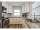 Bright kitchen featuring white cabinets, granite countertops, and stainless steel appliances at 907 E 9Th Ave, Gastonia, NC 28054