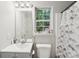 Bright bathroom with a gray vanity, window, and shower with patterned curtain at 9200 Forest Green Dr, Charlotte, NC 28227