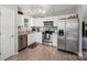 Well lit kitchen area featuring white cabinets and stainless steel appliances at 9200 Forest Green Dr, Charlotte, NC 28227